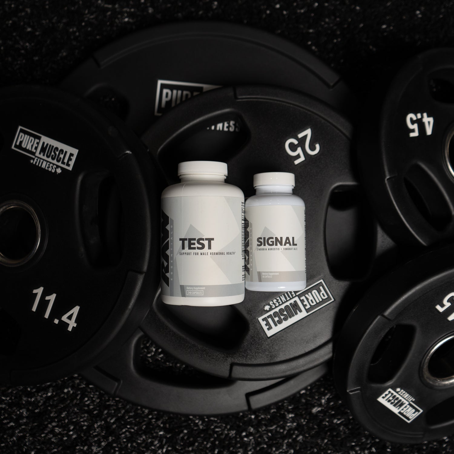 RAW 'Test' and 'Signal' supplements placed on Pure Muscle Fitness weight plates.